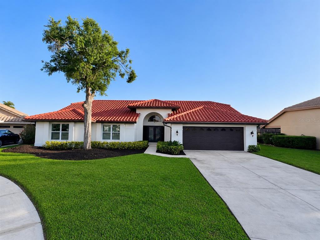A single-story house with a red tile roof, white stucco walls, and a two-car garage — 4804 LONGWATER WAY, TAMPA, FL