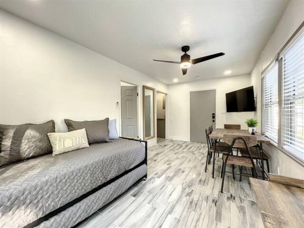 A studio room features a daybed, a dining table with chairs, and light wood-look flooring — 2008 PAGE AVE UNIT 3, ORLANDO, FL