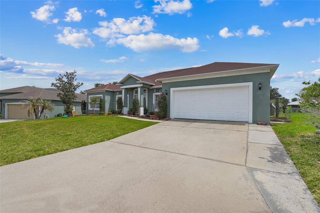A single-story house with a green exterior, a two-car garage, and a concrete driveway — 2735 BERKFORD CIRCLE, LAKELAND, FL