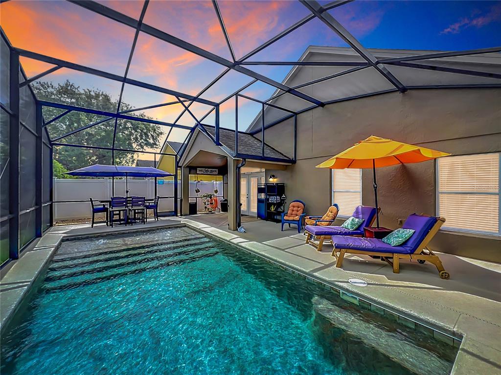 A swimming pool with a screened enclosure, lounge chairs, and a covered patio area — 2886 SWEETSPIRE CIRCLE, OVIEDO, FL