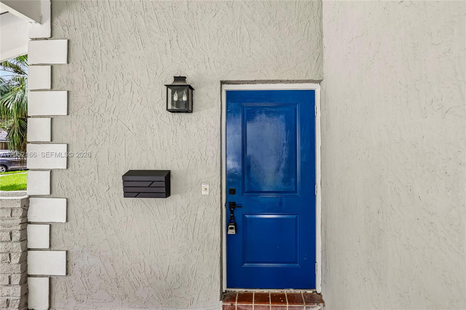 A bright blue door is set into a light gray stucco wall with a mailbox — 130 NW 85th St, Miami FL 33150, MIAMI, FL