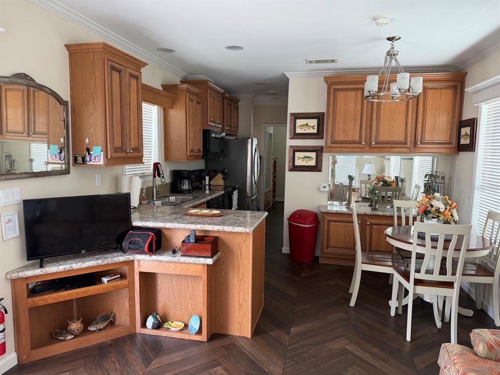 A kitchen with wood cabinets, laminate countertops, and a dining area with a round table — 2414 LIMEWOOD AVENUE, CLERMONT, FL