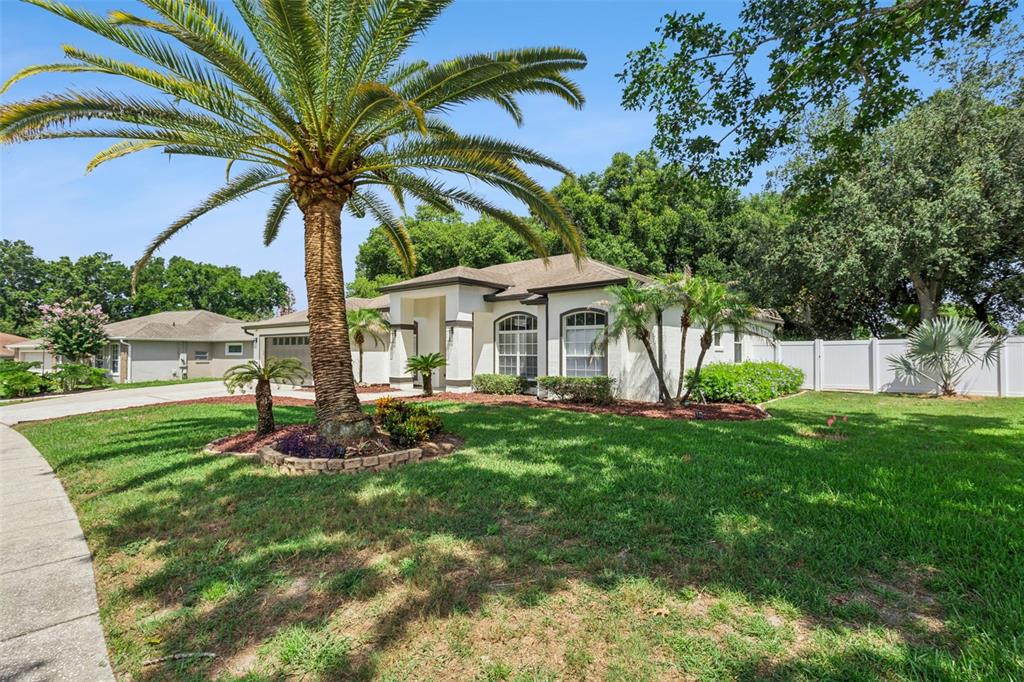 A single-story house with a palm tree in the front yard and a white fence — 16413 ARROWHEAD TRL, CLERMONT, FL