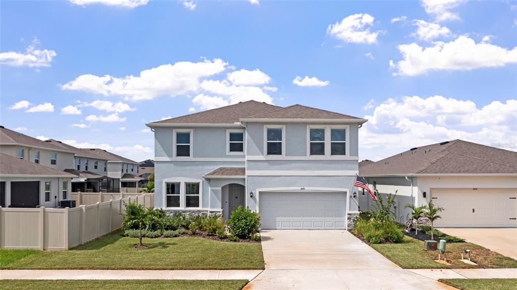 A two-story light blue house with a two-car garage and a front lawn — 4410 DUSKY DAWN LANE, PALMETTO, FL