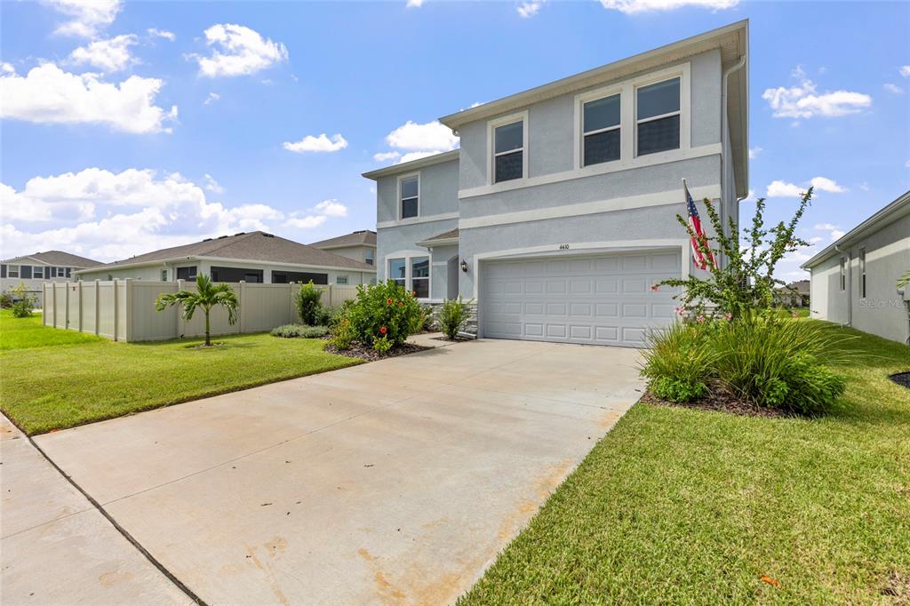 A two-story house with a light blue exterior, a two-car garage, and a concrete driveway — 4410 DUSKY DAWN LANE, PALMETTO, FL