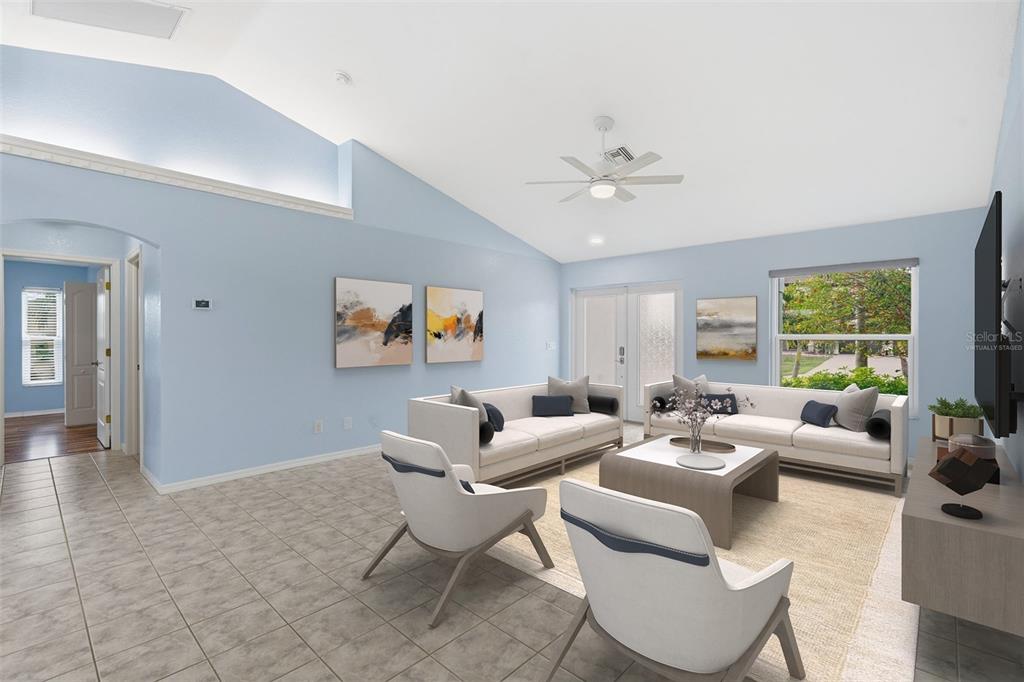 A virtually staged living room with light blue walls, vaulted ceilings, and tile flooring — 2803 SW 34TH TERRACE, CAPE CORAL, FL