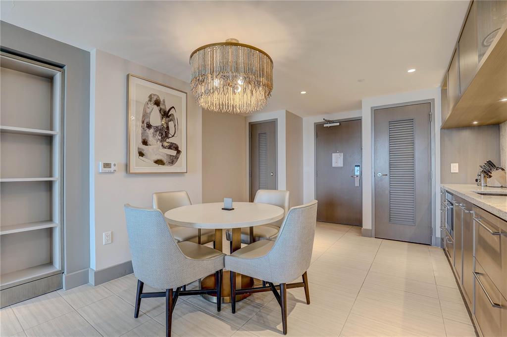 A dining area features a round table, four upholstered chairs, and a decorative chandelier — 691 S GULFVIEW BOULEVARD UNIT 1608, CLEARWATER BEACH, FL