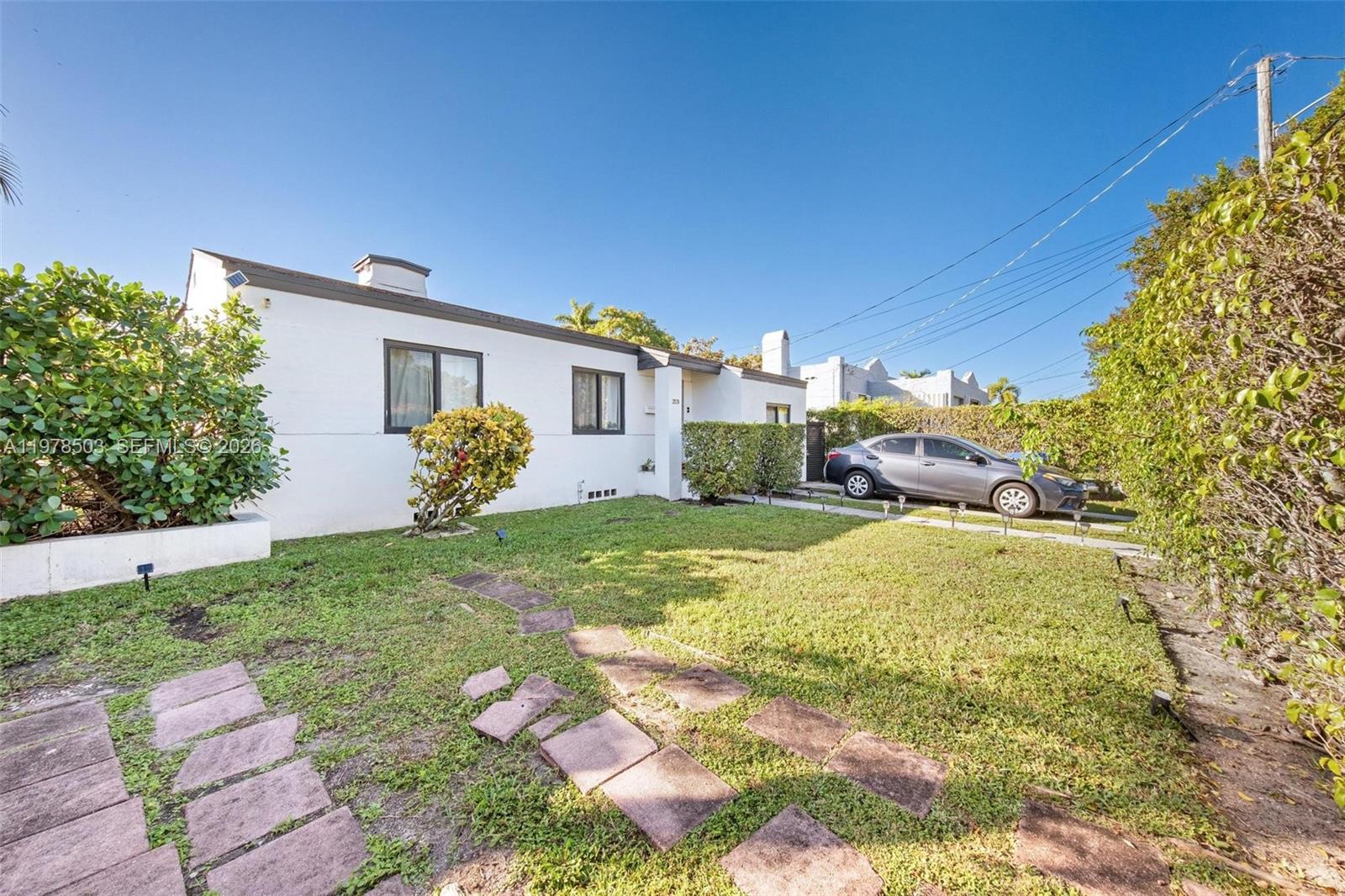 A white single-story house features a front lawn, a stone walkway, and a parked car — 2520 SW 20th St # 1, Miami FL 33145, MIAMI, FL