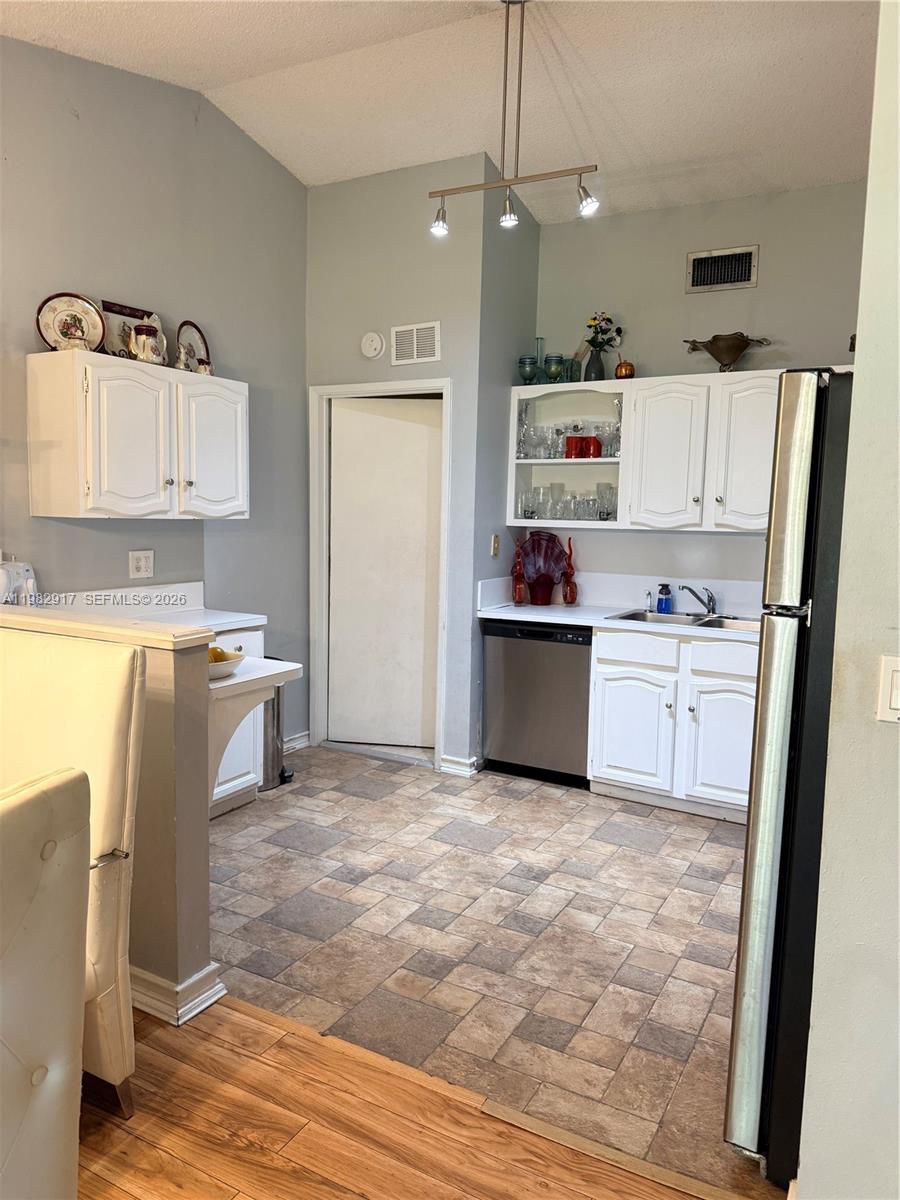 A kitchen features white cabinetry, stainless steel appliances, and a tiled floor — 9963 Baywater Dr, Boca Raton FL 33496, BOCA RATON, FL