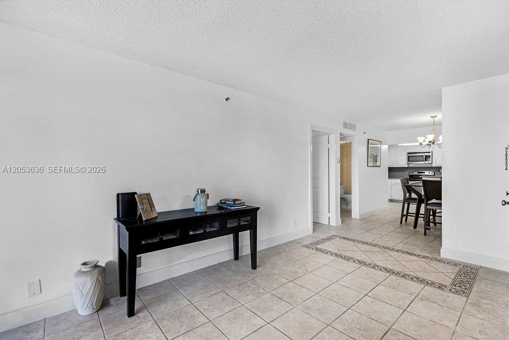 A tiled entryway leads to a dining area and kitchen with a black console table — 2625 Collins Ave # 702, Miami Beach FL 33140, MIAMI BEACH, FL