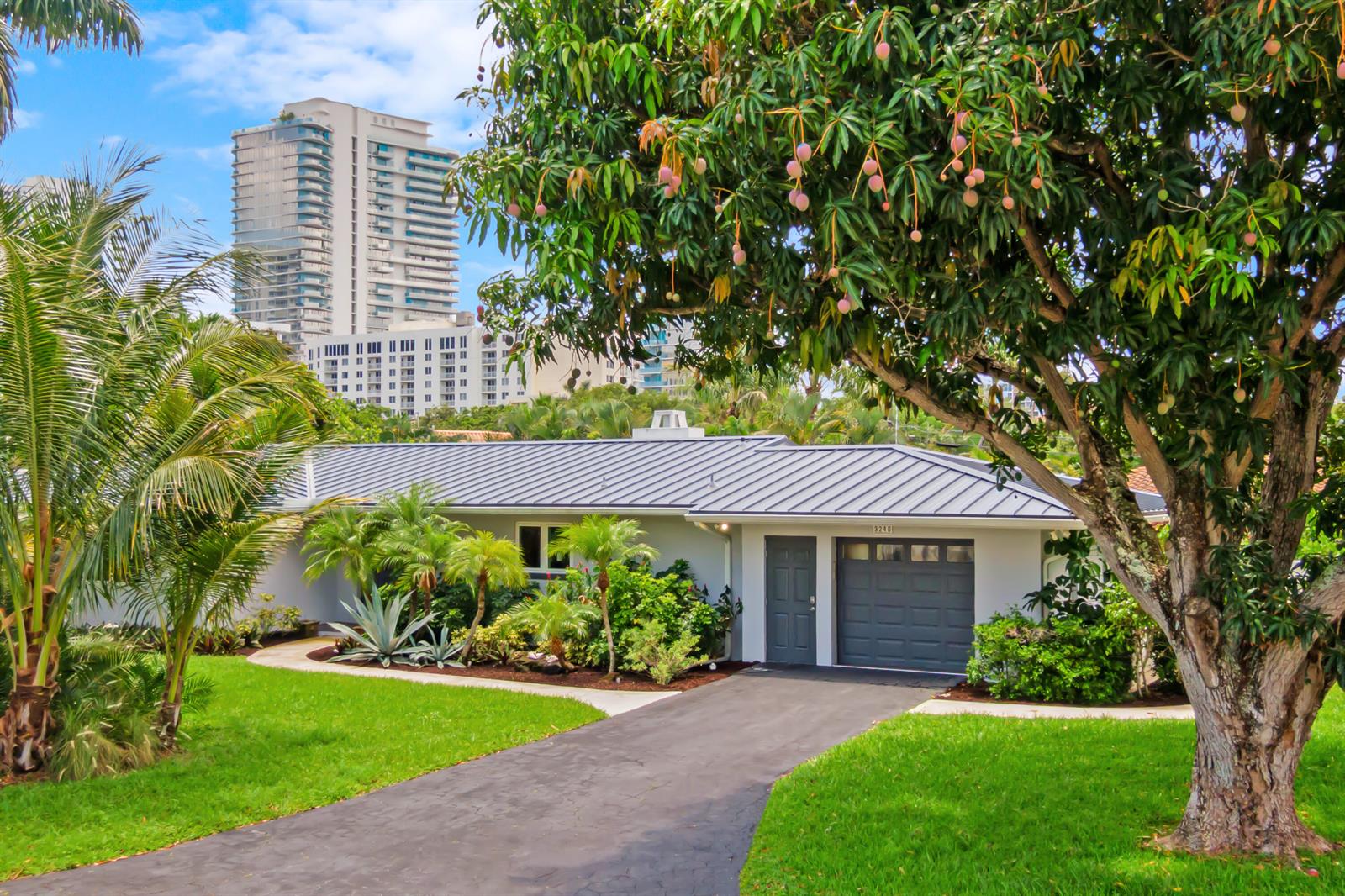 A single-story house with a gray metal roof and a driveway in a tropical setting — 3240 Lakeview Drive, Pompano Beach FL 33062, POMPANO BEACH, FL