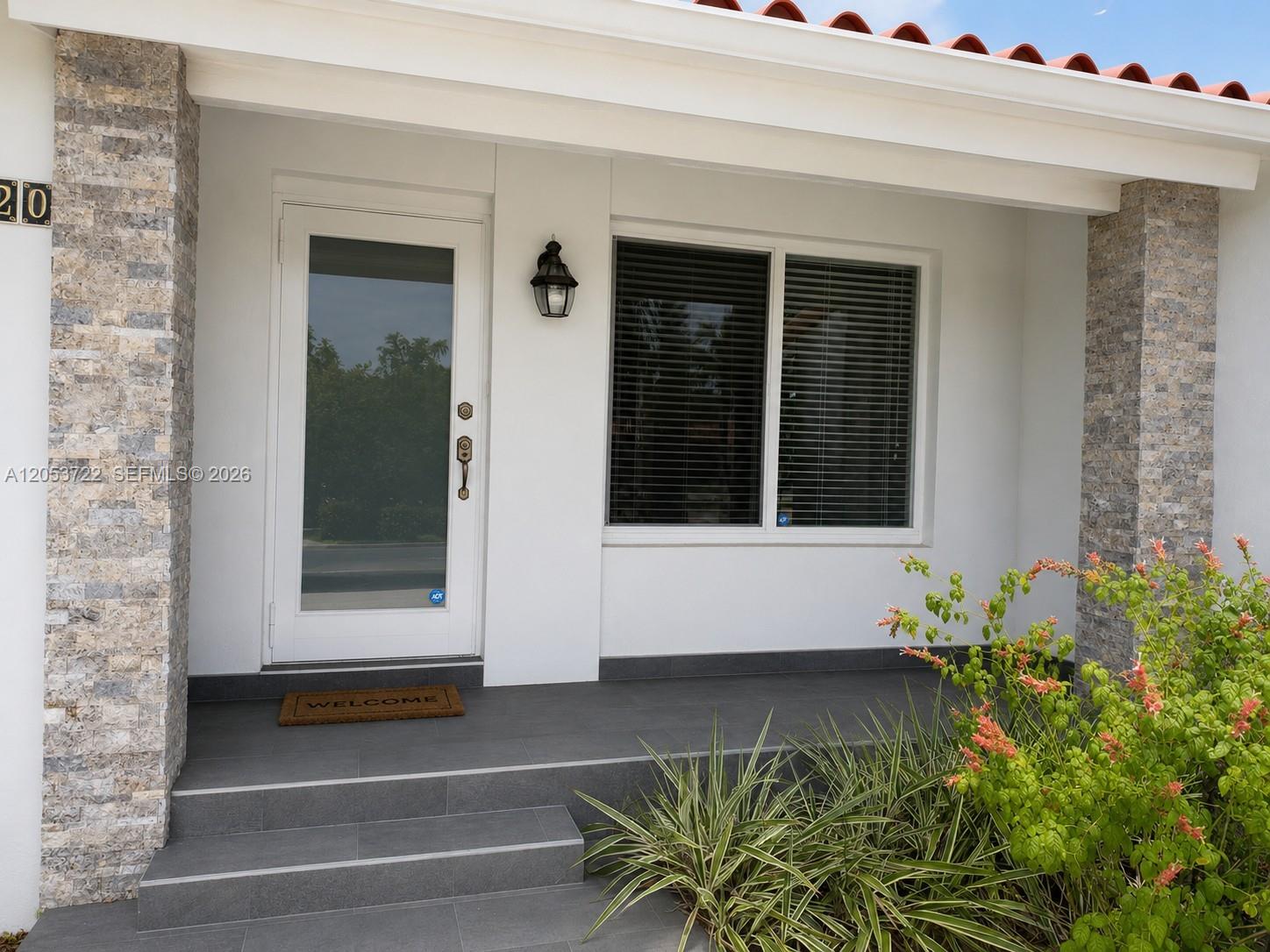 The exterior entrance features a white door, a window with blinds, and stone-clad pillars — 6320 SW 24th St, Miami FL 33155, MIAMI, FL