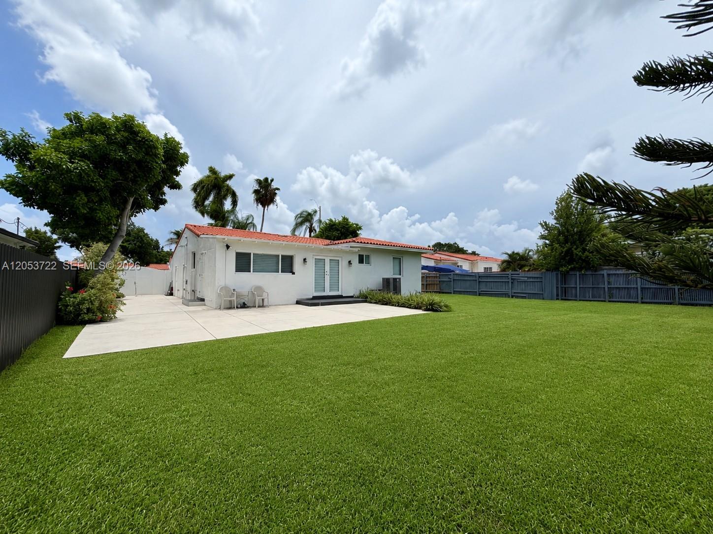 The exterior of a white house with a red tile roof and a large lawn — 6320 SW 24th St, Miami FL 33155, MIAMI, FL