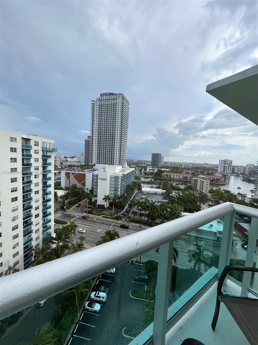 A high-angle view from a balcony overlooking a city street, palm trees, and tall buildings — 3901 S S Ocean dr, Hollywood FL 33019, HOLLYWOOD, FL