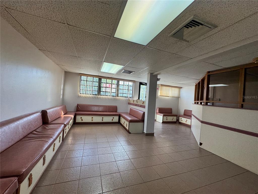 A waiting room features built-in vinyl benches, tiled flooring, and a drop ceiling with lights — MARGINAL ELIOT VELEZ ST. ATENAS UNIT J-14, MANATI, PR