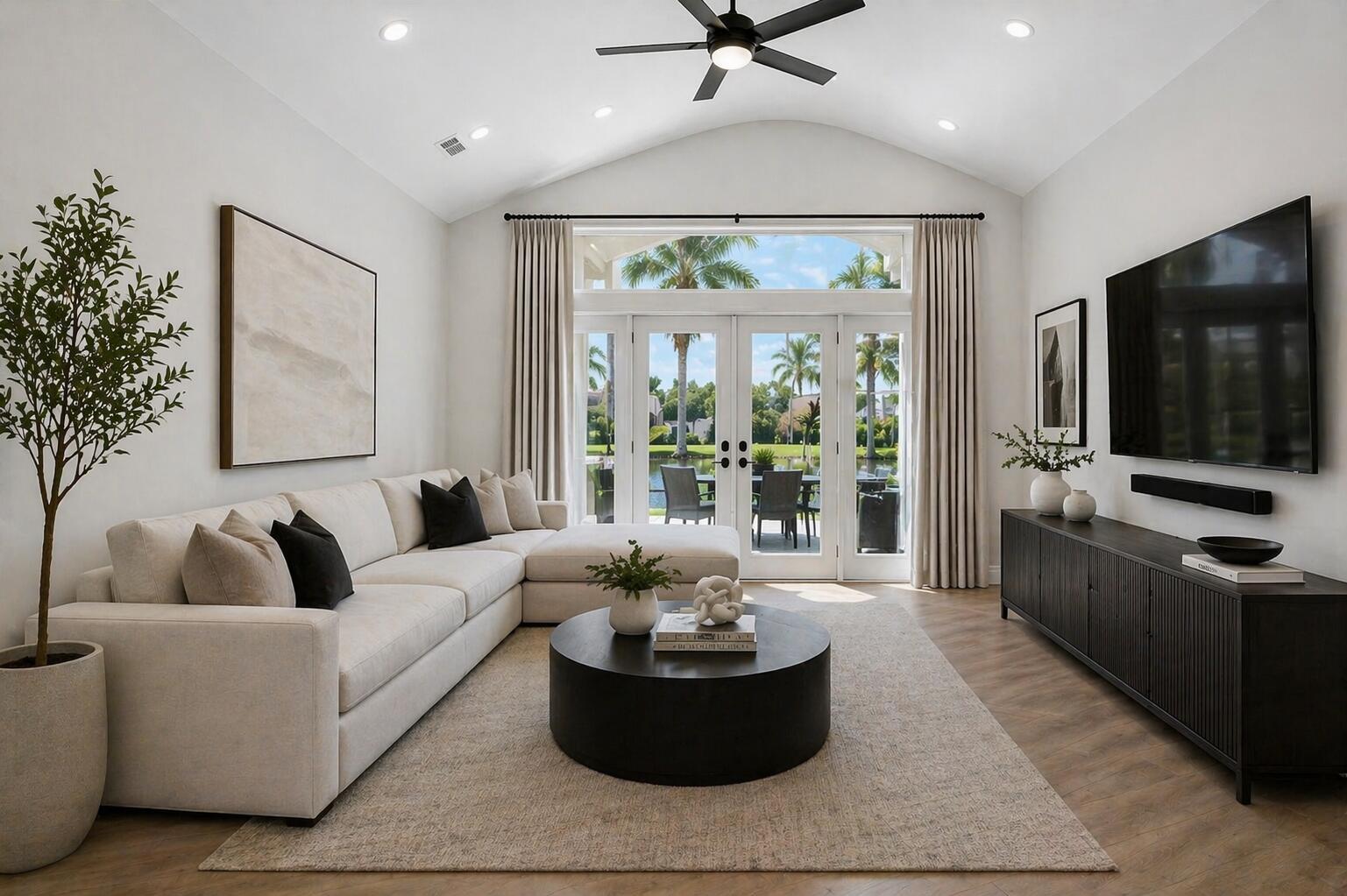 A modern living room features a sectional sofa, round coffee table, and glass patio doors — 7528 Tarpon Cove Circle, Lake Worth FL 33467, LAKE WORTH, FL