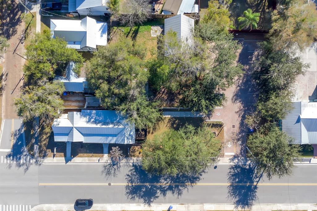 An aerial view shows several buildings with metal roofs surrounded by trees and parking areas — 702 MABBETTE STREET, KISSIMMEE, FL