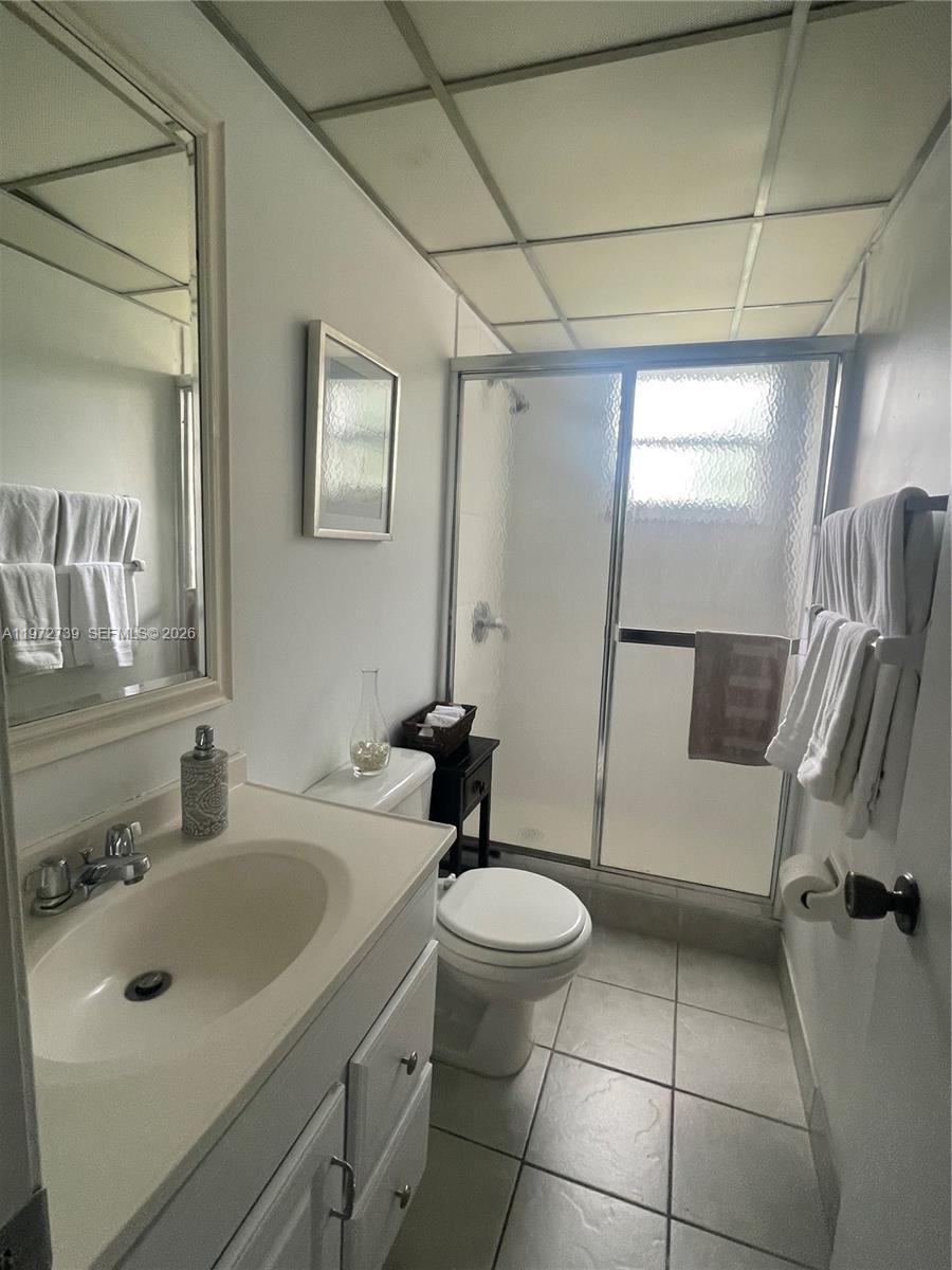 A bathroom features a white vanity, a toilet, and a glass-enclosed shower stall — 201 178th Dr # 334, Sunny Isles Beach FL 33160, SUNNY ISLES BEACH, FL