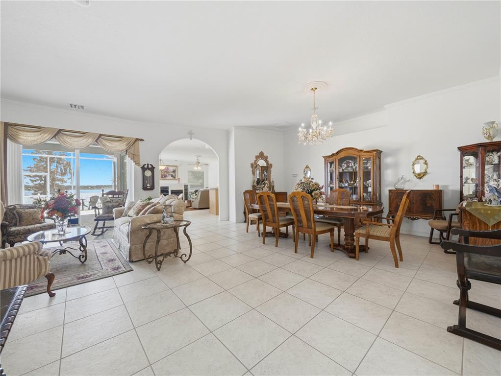A spacious living and dining area with tile floors, a chandelier, and a lake view — 118 W JULIANA WAY, AUBURNDALE, FL