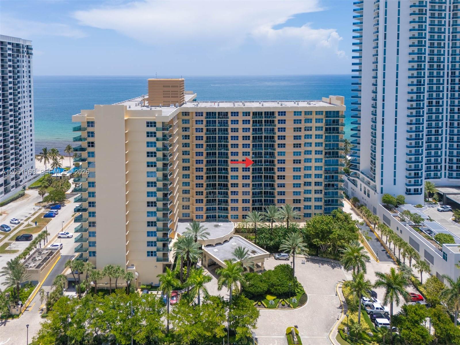 An aerial view of a multi-story beachfront condominium building with a red arrow pointing toward a balcony — 2501 S Ocean Dr # 828, Hollywood FL 33019, HOLLYWOOD, FL