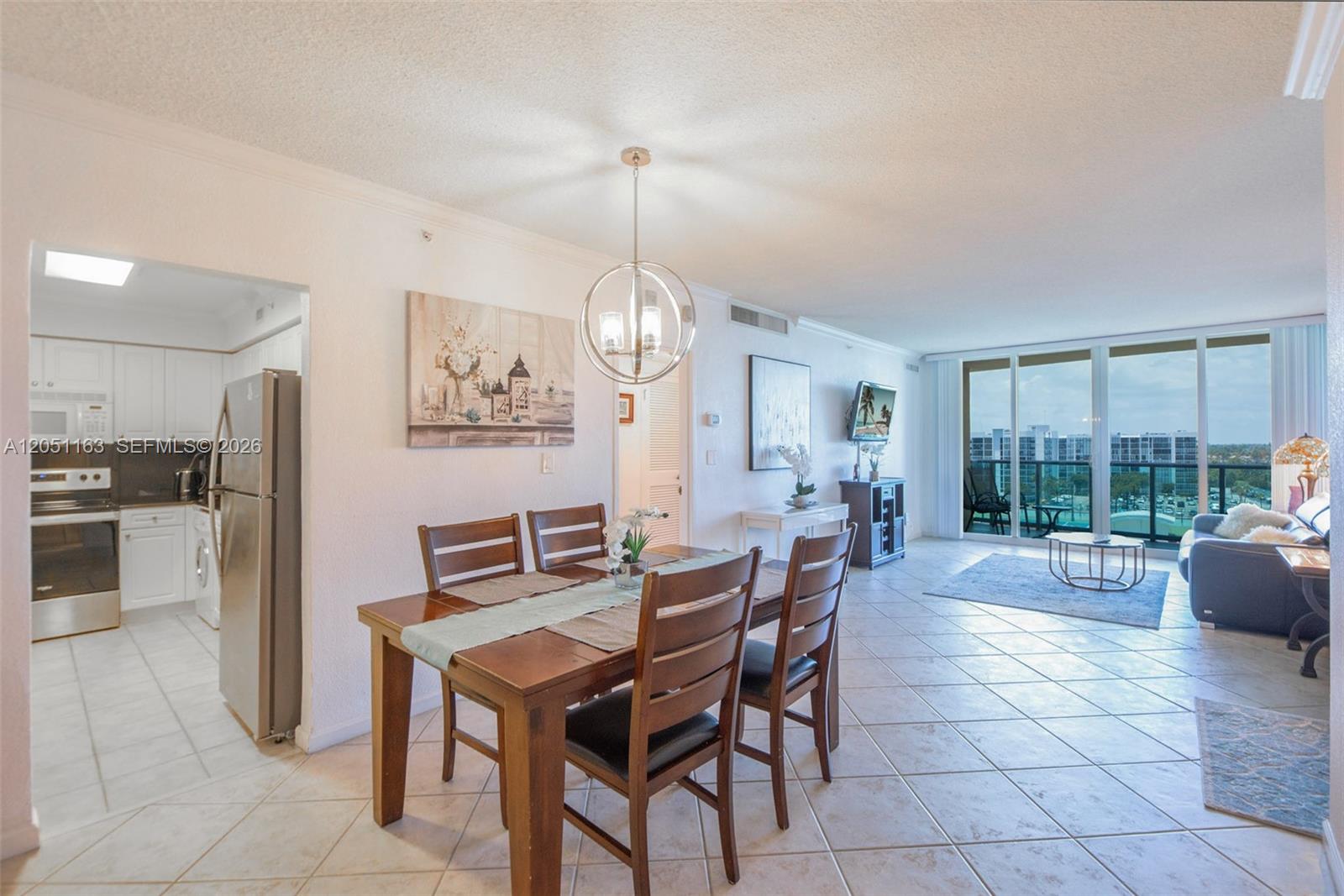 A dining area and living room with tile floors overlook a balcony with a city view — 2501 S Ocean Dr # 828, Hollywood FL 33019, HOLLYWOOD, FL