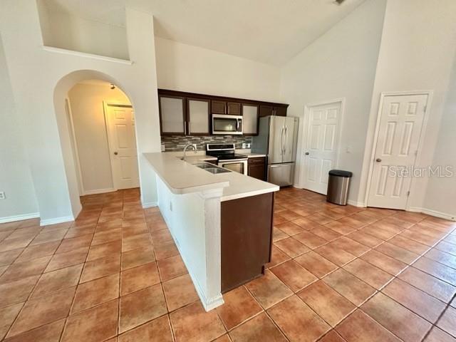 A kitchen features dark wood cabinets, stainless steel appliances, and a tiled floor — 4627 EAGLET LANE, KISSIMMEE, FL