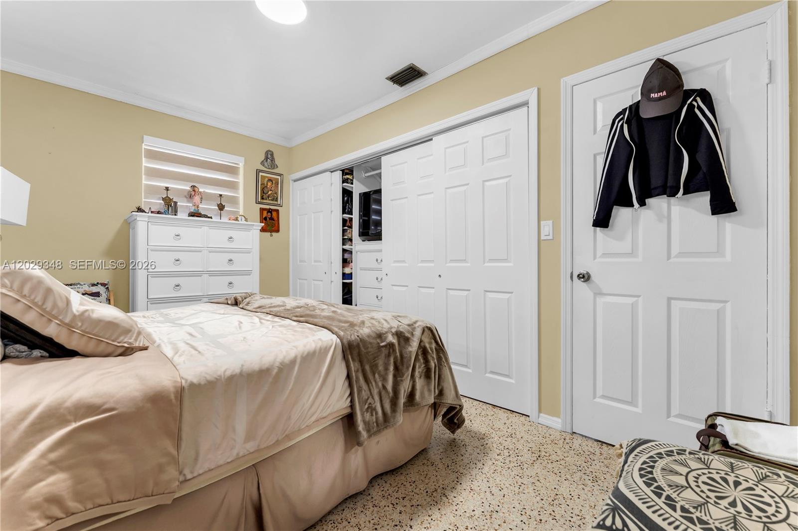 A bedroom features a bed, a white dresser, a closet with sliding doors, and terrazzo flooring — 884 W 72nd Pl, Hialeah FL 33014, HIALEAH, FL