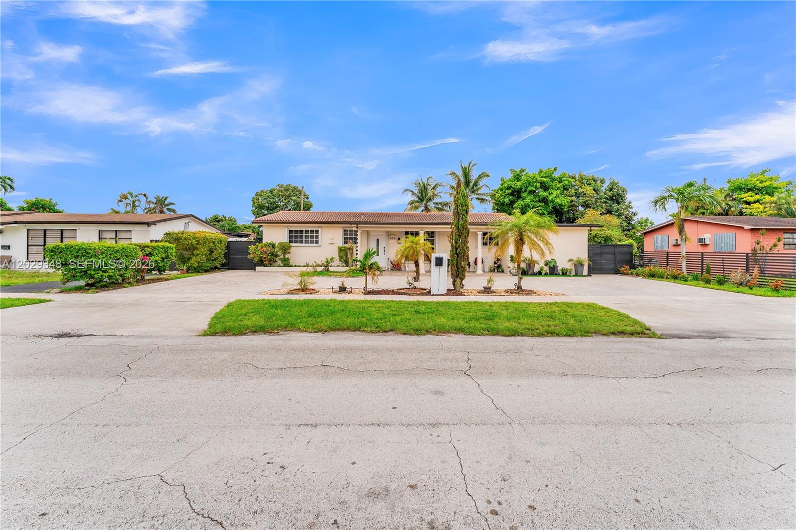 A single-story house with a large concrete driveway and palm trees in the front yard — 884 W 72nd Pl, Hialeah FL 33014, HIALEAH, FL