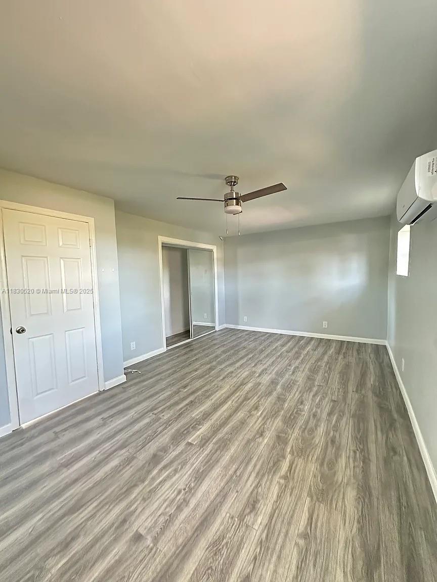 An empty room features light gray walls, wood-look flooring, a ceiling fan, and mirrored closet doors — 4410 26th Ave # 2, Vero Beach FL 32967, VERO BEACH, FL