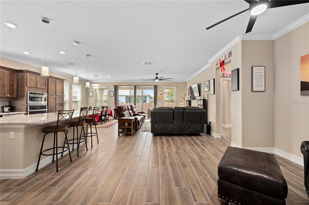 An open-concept living area features a kitchen with bar seating, dining space, and tile flooring — 4252 NW 55TH TERRACE, OCALA, FL