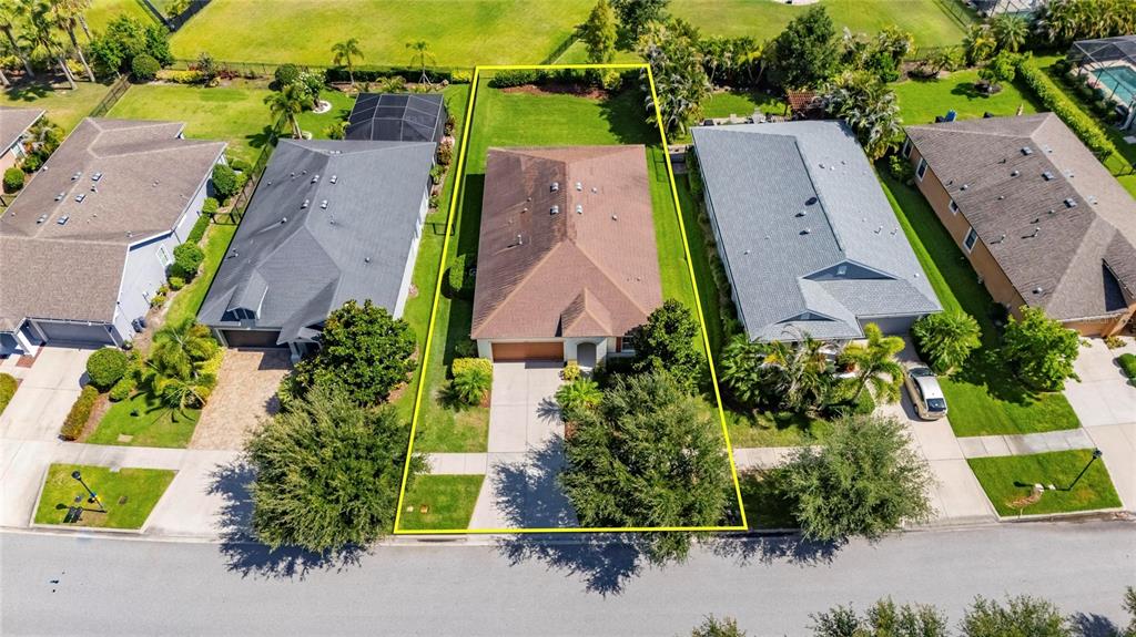 An aerial view shows a single-story house with a brown roof and a front driveway — 7328 MILESTONE DRIVE, APOLLO BEACH, FL