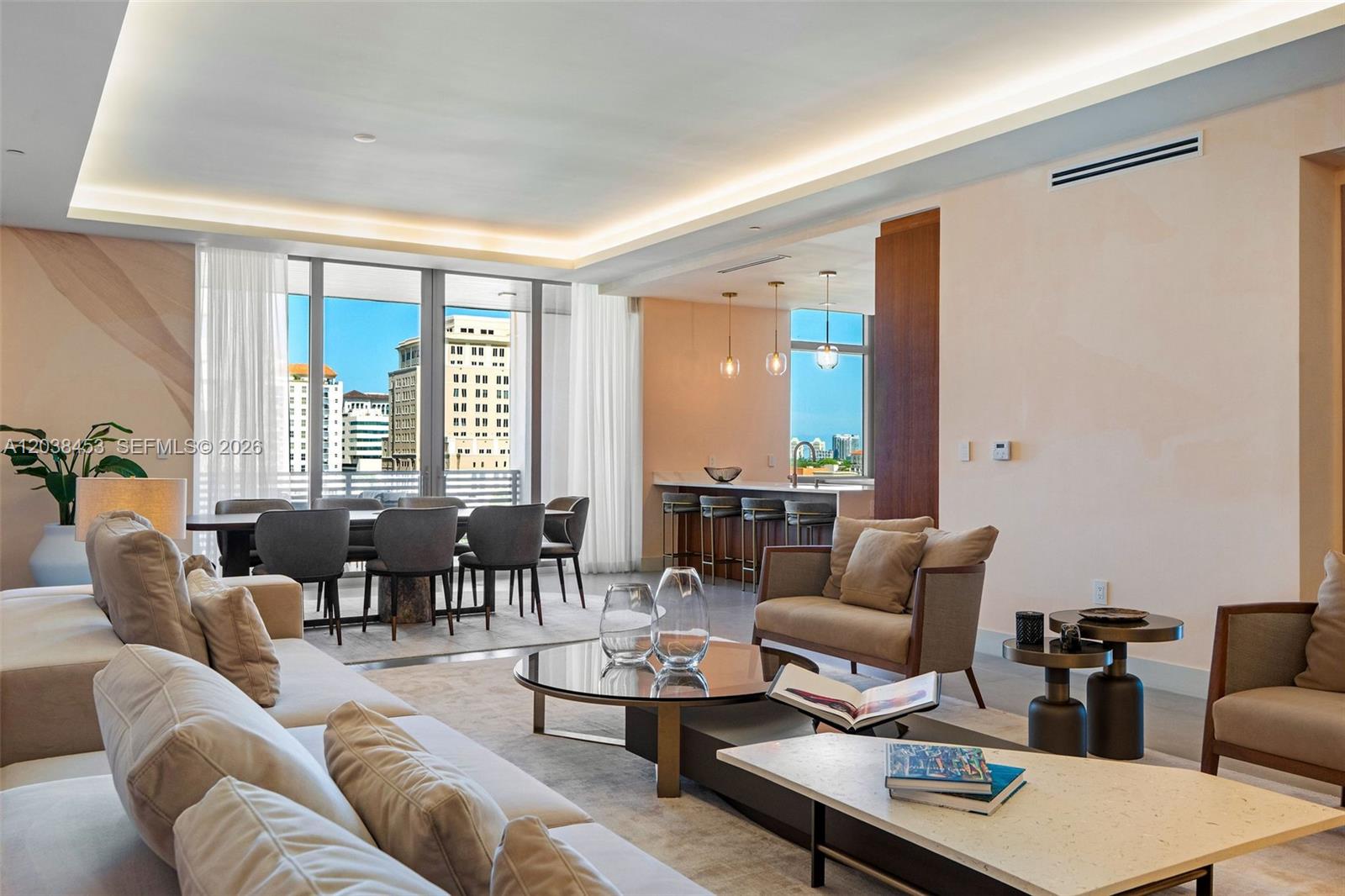 A modern open-plan living and dining area features neutral furniture, a kitchen island, and floor-to-ceiling windows — 515 Valencia Ave # 802, Coral Gables FL 33134, CORAL GABLES, FL