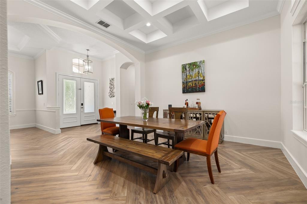 A dining room with a wooden table, orange chairs, and a coffered ceiling — 8351 BOWDEN WAY, WINDERMERE, FL