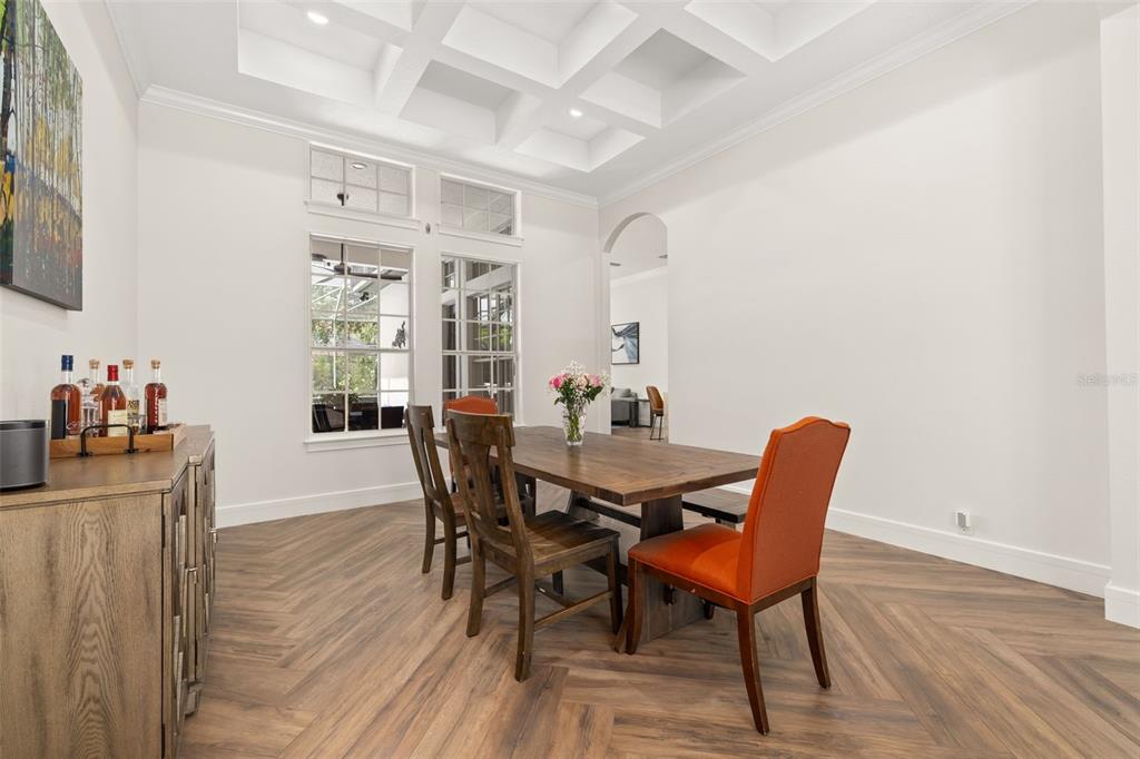 A dining room features a coffered ceiling, herringbone wood floors, and a wooden table — 8351 BOWDEN WAY, WINDERMERE, FL