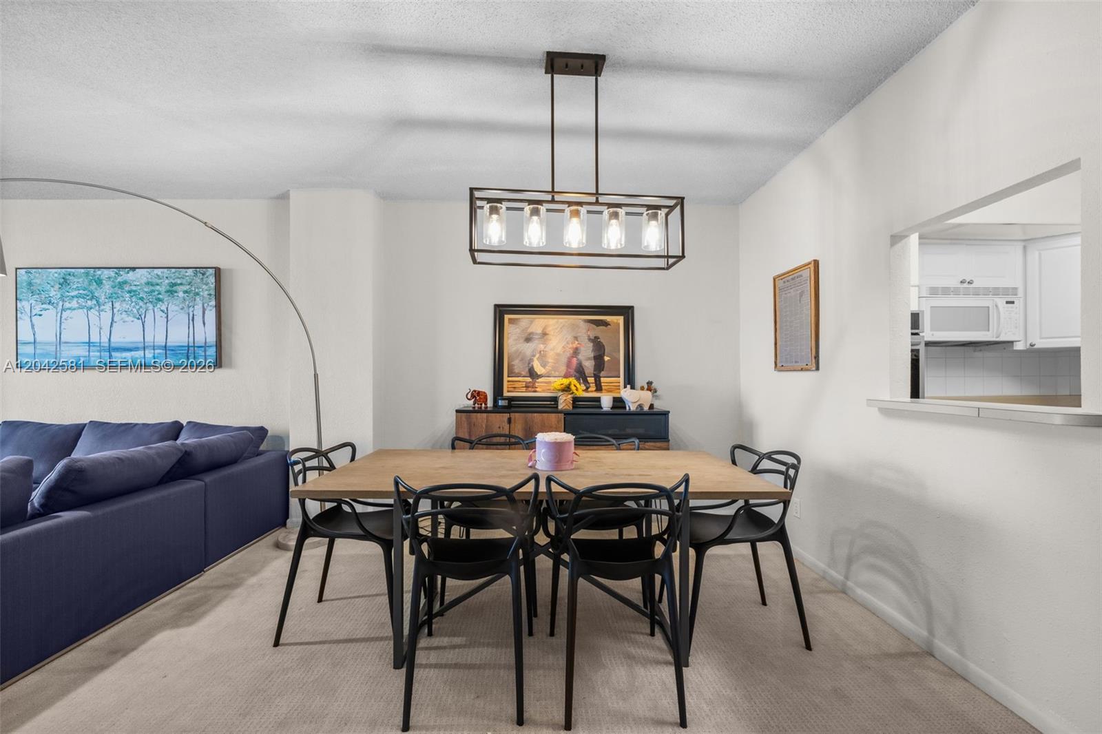 A dining area features a wooden table, black chairs, and a rectangular pendant light fixture — 19380 Collins Ave # 1224, Sunny Isles Beach FL 33160, SUNNY ISLES BEACH, FL