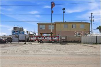 A two-story building with a gravel lot and a flag pole in front — 545 150TH AVENUE, MADEIRA BEACH, FL