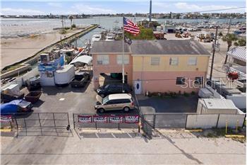 An aerial view of a two-story building with a parking lot and a boat dock — 545 150TH AVENUE, MADEIRA BEACH, FL