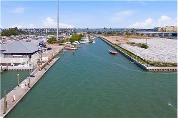 An aerial view shows a narrow canal leading to a bay with docks and boats — 545 150TH AVENUE, MADEIRA BEACH, FL