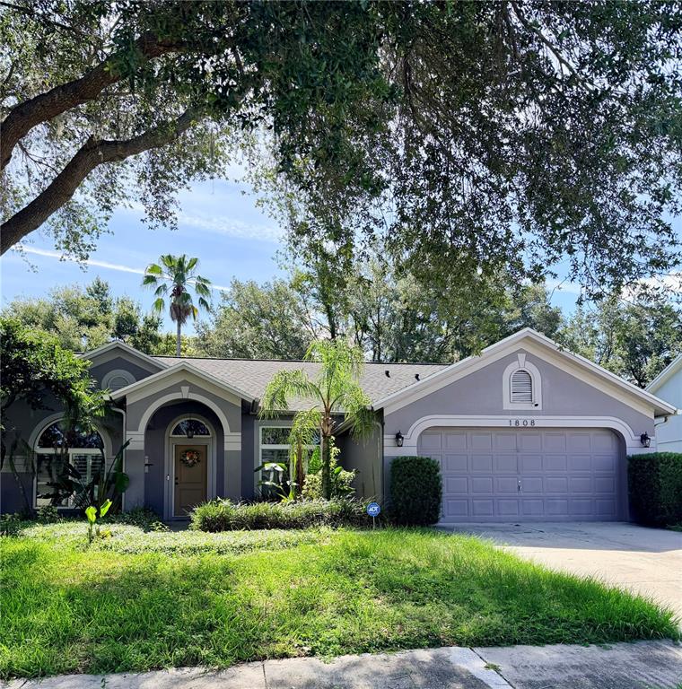 A single-story house with a gray exterior, a two-car garage, and a front entryway — 1808 POWDER RIDGE DRIVE, VALRICO, FL