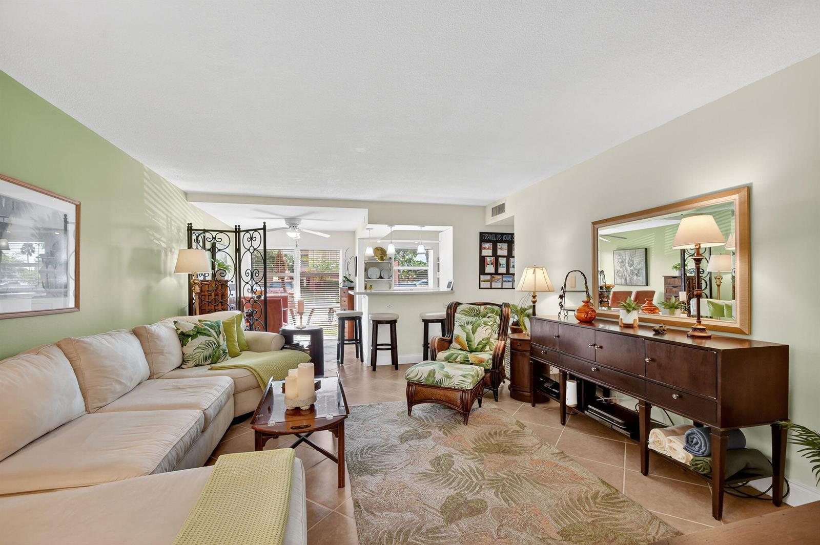 A living room features a sectional sofa, a patterned armchair, and a dark wood sideboard — 7 Golfs Edge # D, West Palm Beach FL 33417, WEST PALM BEACH, FL