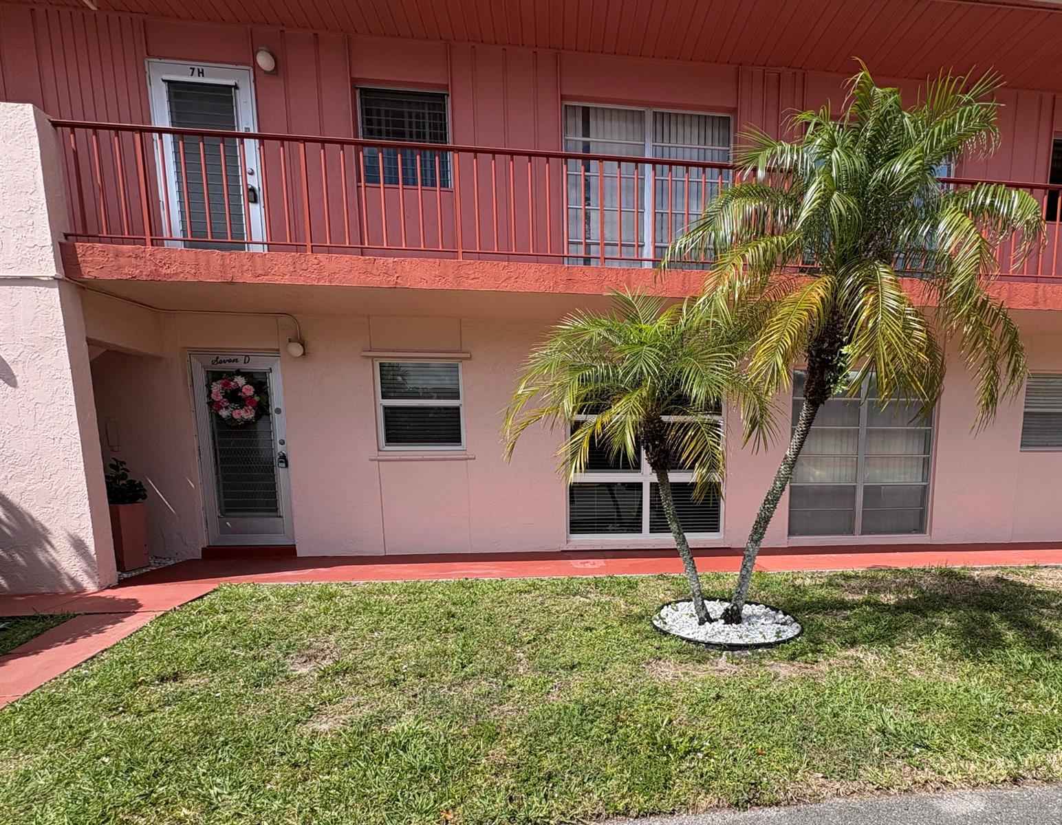 A two-story pink apartment building features a palm tree in the front yard — 7 Golfs Edge # D, West Palm Beach FL 33417, WEST PALM BEACH, FL