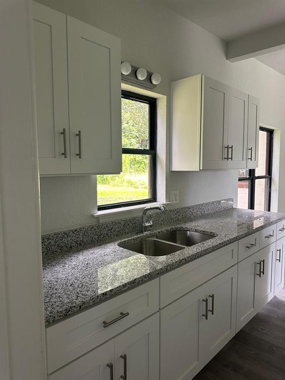 A kitchen features white cabinets, granite countertops, a double-basin sink, and a window — 4514 ARCH STREET, ORLANDO, FL