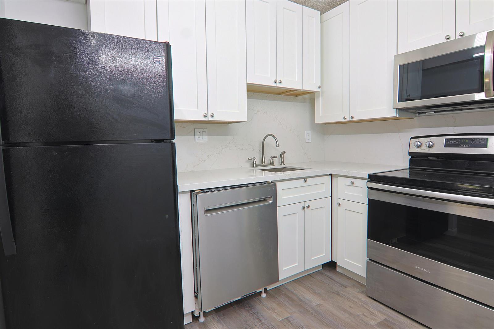A kitchen features white cabinets, stainless steel appliances, a black refrigerator, and quartz countertops — 6931 SW 129th Avenue # 3, Miami FL 33183, MIAMI, FL