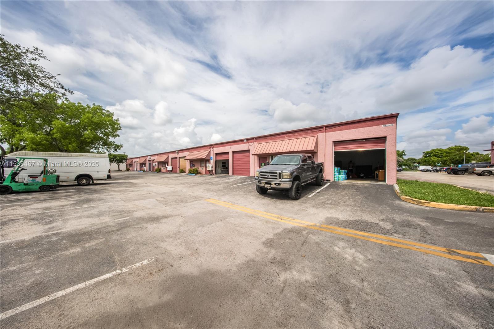 A row of pink industrial warehouse units with roll-up doors and a parking lot — 1375 NW 65TH AV, Plantation FL 33313, PLANTATION, FL