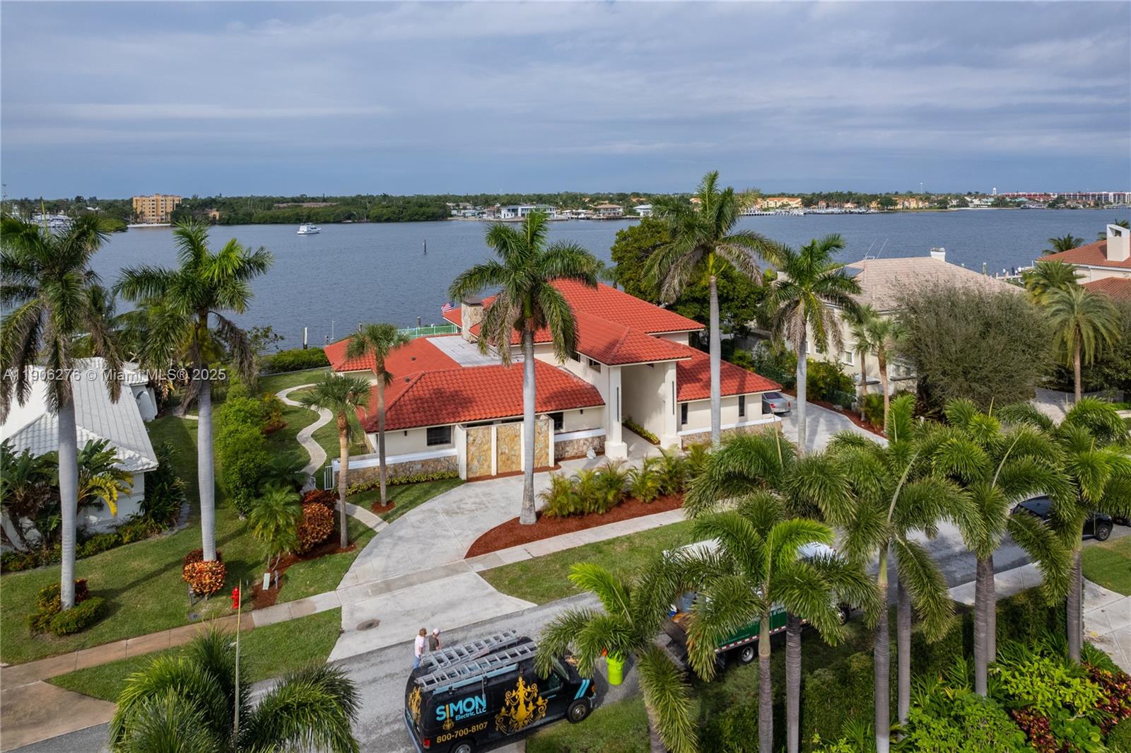 An aerial view shows a waterfront house with a red tile roof and palm trees — 1635 Lands End Rd, Manalapan FL 33462, MANALAPAN, FL