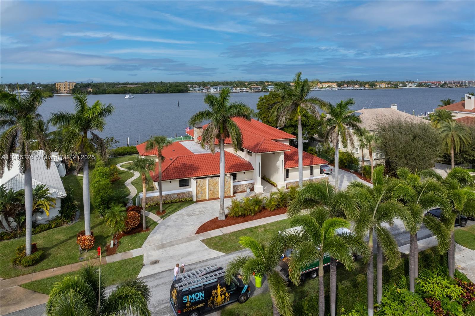 An aerial view shows a waterfront house with a red tile roof and palm trees — 1635 Lands End Rd, Manalapan FL 33462, MANALAPAN, FL