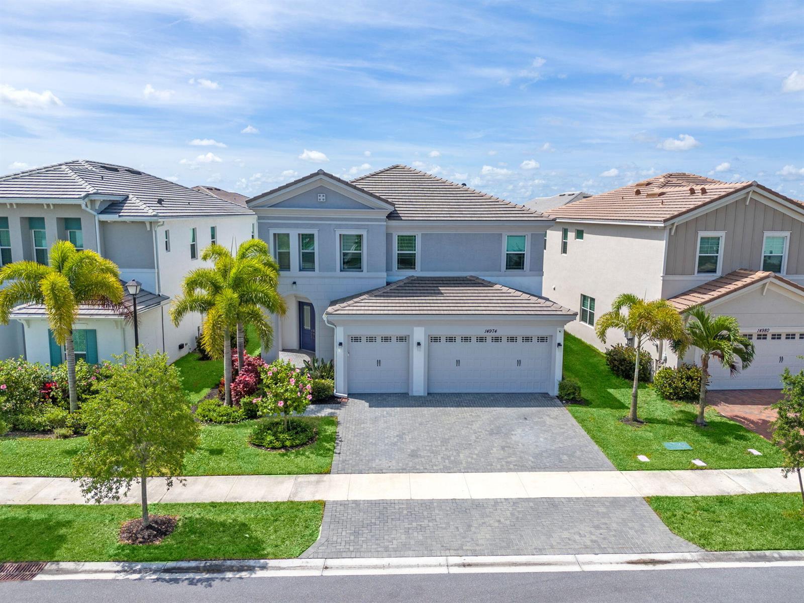 A two-story suburban house with a gray exterior, tiled roof, and a paved driveway — 14974 Goldspar Court, Westlake FL 33470, WESTLAKE, FL