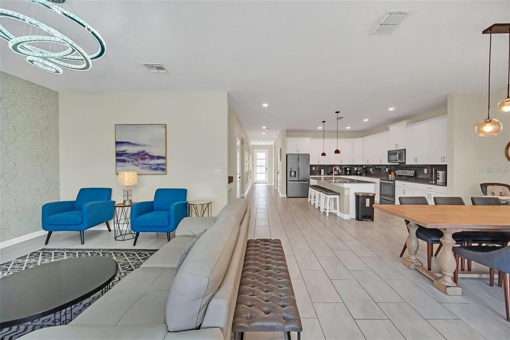 An open-concept living area features a kitchen, dining space, and lounge with tile flooring — 2748 BOOKMARK DRIVE, KISSIMMEE, FL