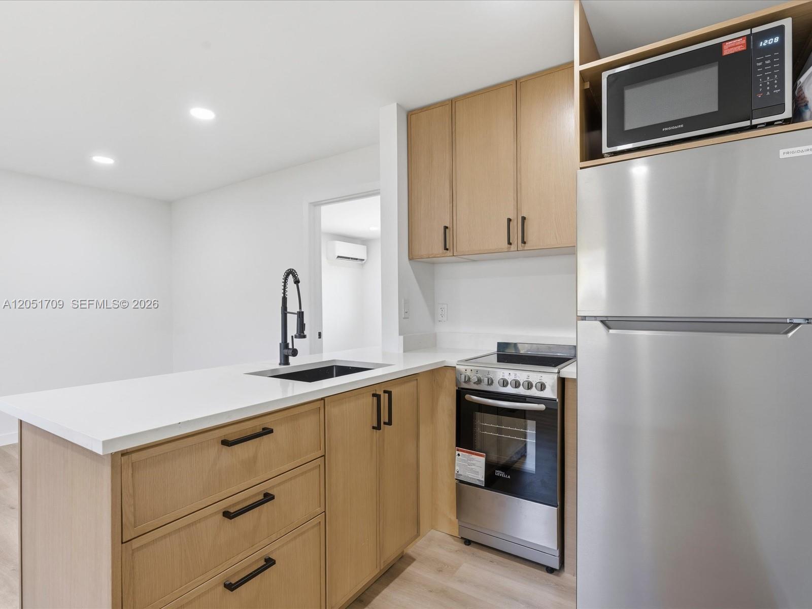 A kitchen features light wood cabinets, stainless steel appliances, and a white countertop — 1129 NE 16th Ave # 1, Fort Lauderdale FL 33304, FORT LAUDERDALE, FL