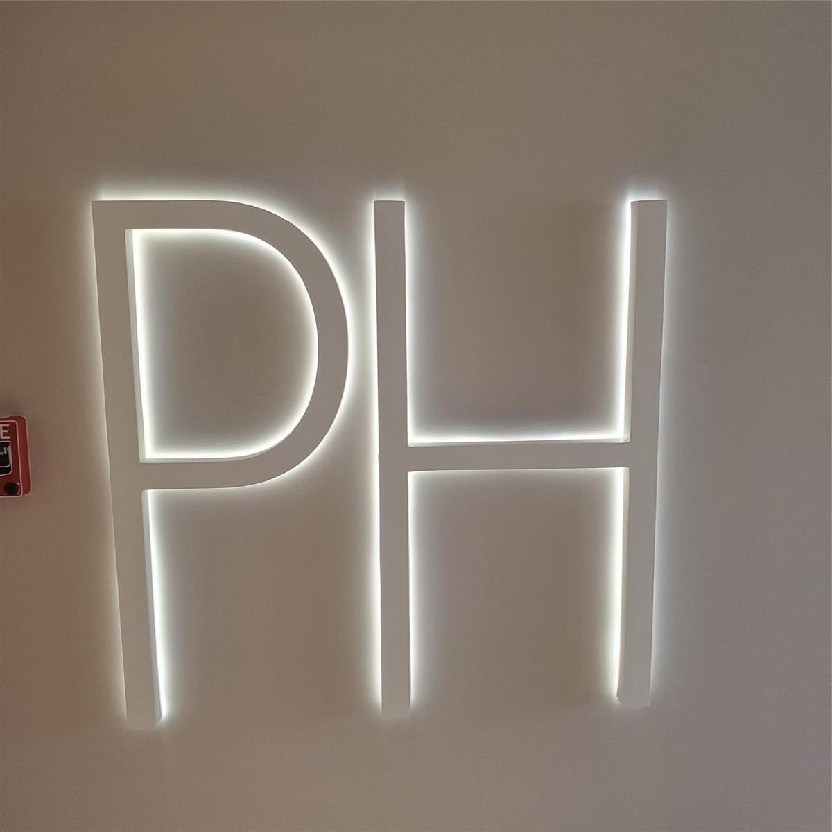 A wall-mounted, backlit sign displays the letters PH in white against a plain wall — 1000 S Ocean Boulevard, Pompano Beach FL 33062, POMPANO BEACH, FL